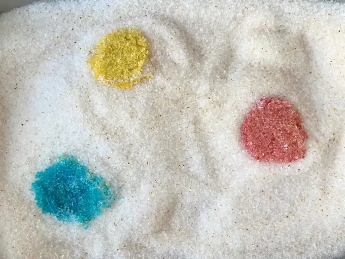 Gros plan sur des cristaux de liti&egrave;re Pacha montrant trois taches de couleur diff&eacute;rentes &mdash; jaune, bleu et rose &mdash; indiquant la d&eacute;tection de sant&eacute; par pH